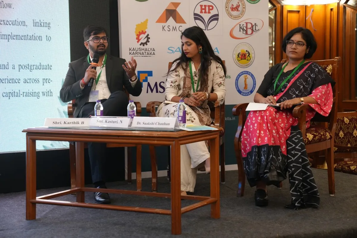 Karthik Beknal speaking on the summit panel, microphone in hand